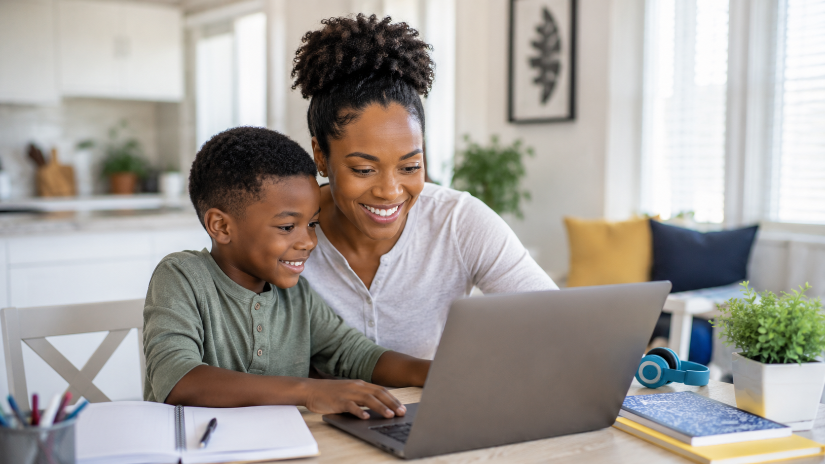 Parent and student smiling together while working on a laptop at home